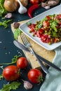 summer salad, tomatoes, green peas, arugula, onion, olive oil, garlic, hot pepper fork knife bamboo cutting board pastel green Royalty Free Stock Photo