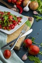 summer salad, tomatoes, green peas, arugula, onion, olive oil, garlic, hot pepper fork knife bamboo cutting board pastel green Royalty Free Stock Photo