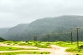 Lush green landscape, trees and foggy mountains in Ayn Khor tourist resort, Salalah, Oman