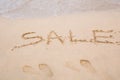 Summer sale handwritten in sand on a beach Royalty Free Stock Photo