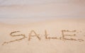 Summer sale handwritten in sand on a beach Royalty Free Stock Photo