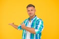 Summer sales here. sexy man yellow background. mature man unshaven face. smiling guy pointing finger, copy space. male