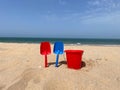 Summer sand beach concept with a red bucket and two red and blue shovels Royalty Free Stock Photo