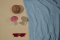 Summer scene with blue beach towel and coconut and red sunglasses and glass with parasol. Minimal concept flat lay