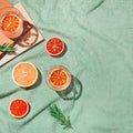 Summer scene with fruits,rosemary, glass of water and books on pastel green beach towel. Drinks and refreshment concept. Sunlit Royalty Free Stock Photo