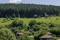 Summer scene with mountain glade, forest and residential district of bulgarian Zhelyava village, Sofia region, Balkan mountain Royalty Free Stock Photo