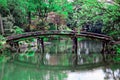 Summer scene of a wooden bridge reflected in the peaceful lake water surrounded by a forest Royalty Free Stock Photo