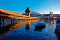 Summer scenery of Chapel Bridge  Kapellbrucke  over Reuss River in Lucerne Old Town, Switzerland, with a boat parking on the riv Royalty Free Stock Photo