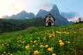 Summer scenery of Dolomites with view of a lovely church at the foothills of rugged mountain peaks Cimon della Pala