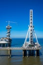 Summer Scheveningen ferris wheel and bungee jumping tower under a pure blue sky