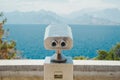 Summer sea landscape with blue sky and mountains. Observation binoculars at the seaside. Relaxation, tranquility and