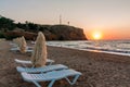 Summer on the sea. Sunset in the resort town. Sun loungers on the beach.