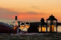 Summer sea sunset. Romantic picnic on the beach. Bottle of wine, glasses, candles, plaid and pillows. Royalty Free Stock Photo