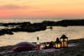 Summer sea sunset. Romantic picnic on the beach. Bottle of wine, glasses, candles, plaid and pillows. Royalty Free Stock Photo