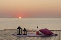 Summer sea sunset. Romantic picnic on the beach. Bottle of wine, glasses, candles, plaid and pillows. Royalty Free Stock Photo