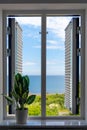 Summer sea voew through the white old wooden opened window with flowers Royalty Free Stock Photo