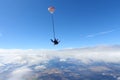 Tandem skydiving. Pretty girl and her instructor are flying in the cloudy sky.