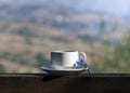 Summer serene morning among nature. Cup of coffee on wooden rural table in mountain valley. Break, breakfast, slow life