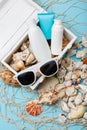 Summer skin care cosmetics, panama and sunglasses on blue background