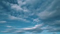 Summer sky. Cirrocumulus and cumulus on different layers clouds on bright blue sky. Wispy cirrocumulus clouds pass over