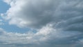 Summer skyscape with dark storm rain clouds on sky. Clouds against a blue sky turning into dark rain cyclones. Timelapse