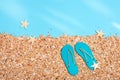 Summer slippers on beach with sand under sunlight, summer background with copy space. Pastel colored Royalty Free Stock Photo