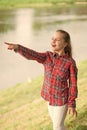 Always summer. Small girl pointing finger at river on summer landscape. Adorable child with long blond hair in casual