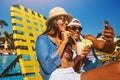 Summer Smile Selfies. an affectionate young couple taking selfies while enjoying a few drinks poolside. Royalty Free Stock Photo