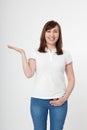 Summer. Smiling beautiful woman wearing blank template white t shirt showing something by hand, mock up on white background Royalty Free Stock Photo