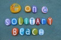 Summer on a solitary beach, vacation dream slogan composed with multi colored stone letters on sand