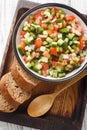 Summer Spanish Salad Pipirrana with green pepper, tomatoes, cucumber, onion and caraway closeup on the plate. Vertical top view