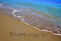 Summer spell written word in sand of a beach