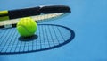 Summer sport concept with tennis ball and racket on blue hard tennis court Royalty Free Stock Photo