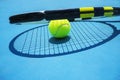 Summer sport concept with tennis ball and racket on blue hard tennis court Royalty Free Stock Photo