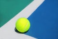 Summer sport concept with tennis ball on white line in the corner of hard tennis court Royalty Free Stock Photo