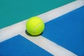 Summer sport concept with tennis ball on white line on hard tennis court. Royalty Free Stock Photo