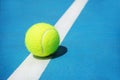 Summer sport concept with tennis ball on white line on hard tennis court Royalty Free Stock Photo