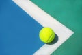 Summer sport concept with tennis ball on white line on hard tennis court. Royalty Free Stock Photo