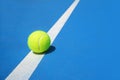 Summer sport concept with tennis ball on white line on hard tennis court blue color Royalty Free Stock Photo