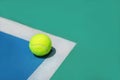 Summer sport concept with tennis ball on white line on hard tennis court. Royalty Free Stock Photo