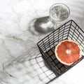 Summer stationery still life scene. Close Up of cut grapefruit fruit on white table background in sunlight. Blank paper cards,