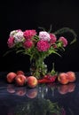 Summer still life with flowers and peaches on a dark background