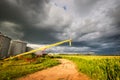 Storm clouds above a corn field and farm equipment. Royalty Free Stock Photo