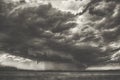 Summer storm cyclone over field hills and forest. Big spooky scary heavy rainy cloud over the valley black and white photography Royalty Free Stock Photo