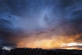 a summer storm at sunset over a city with a sky in shades of orange and blue, contrasting bluish and orange complementary colors Royalty Free Stock Photo