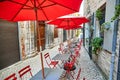 Summer street cafe with red umbrellas and chairs Royalty Free Stock Photo