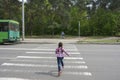 In the summer, on the street, a little girl crosses the road on a pedestrian crossing Royalty Free Stock Photo