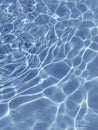 Summer sun dancing on the top of a pool of clear blue water Royalty Free Stock Photo