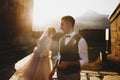 Summer sun shines over stunning wedding couple walking in lonely Georgian town