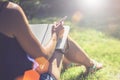 Summer sunny day. Back view. Young woman sits in a park on a lawn and makes notes in a notebook. The girl works, studies Royalty Free Stock Photo